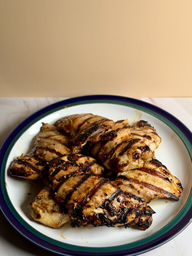 Grilled Asian-style chicken thighs with charred grill marks on a plate