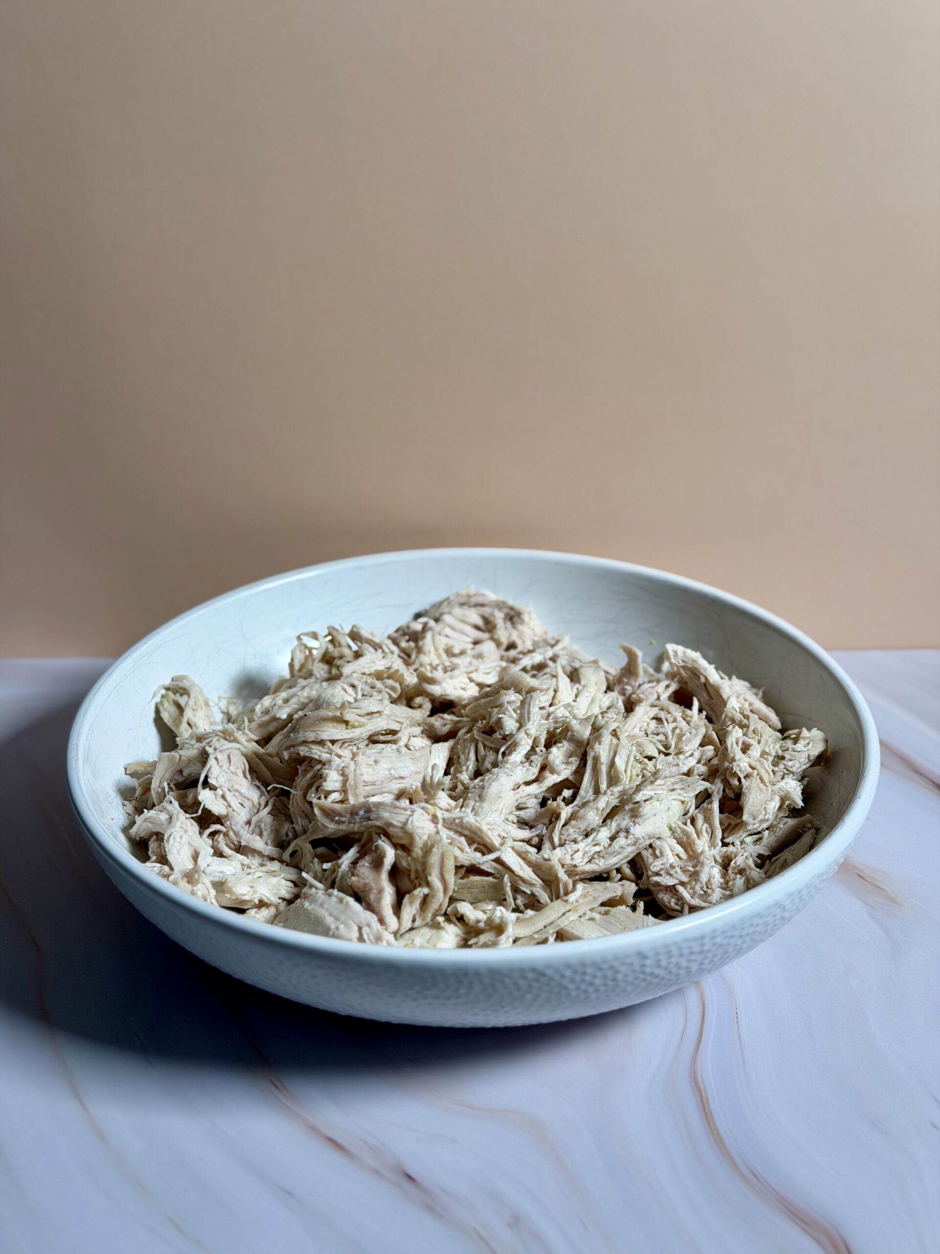 Juicy Instant Pot shredded chicken in a bowl after cooking