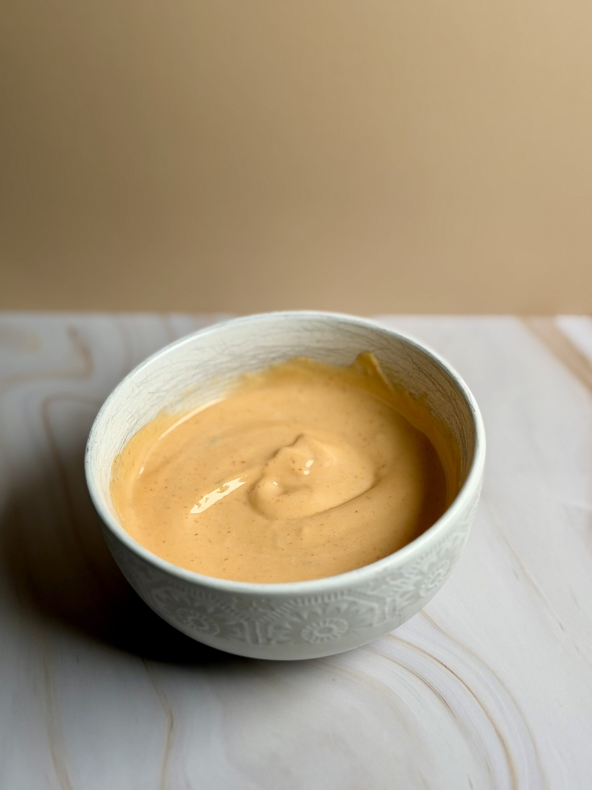 Sriracha mayo in a small bowl, creamy and smooth with lime and sesame oil
